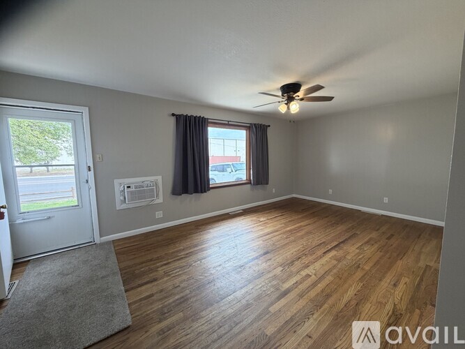 A room with wooden flooring and a ceiling fan.