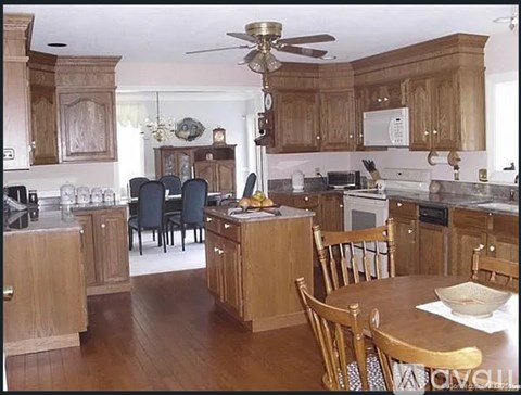 A kitchen with wooden cabinets and a table set for four.