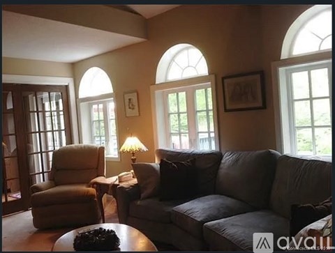 A living room with a couch, chair, and table.