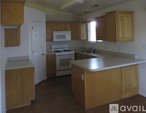 A kitchen with wooden cabinets and a white stove top oven.