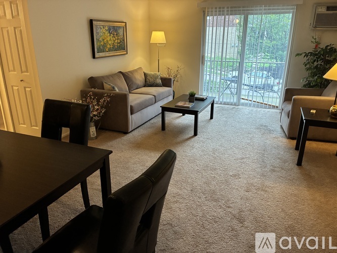 A living room with a couch, chairs, and a coffee table.