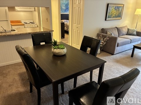 A black table with four chairs and a plant on it.
