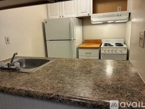 A kitchen with granite countertops and a white stove.
