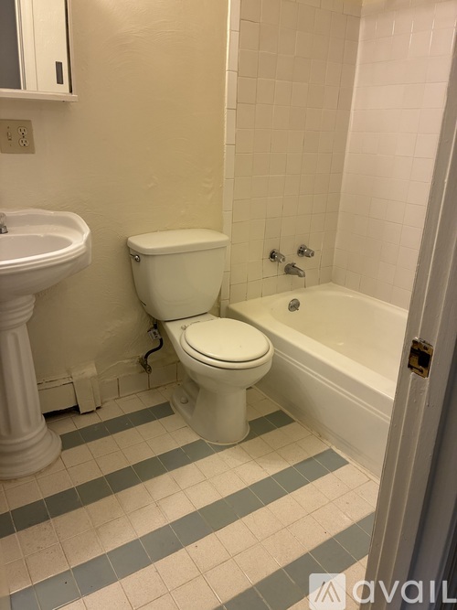 A bathroom with a toilet, sink, and bathtub.