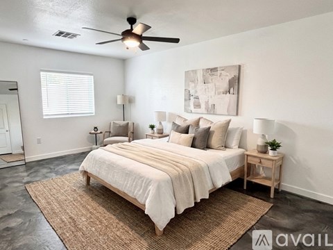 A bedroom with a large bed and a ceiling fan.
