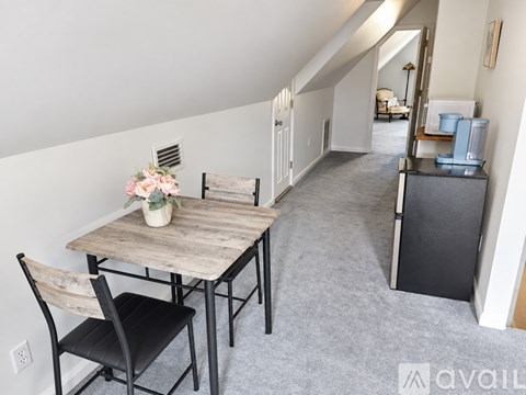 A dining room with a wooden table and chairs.