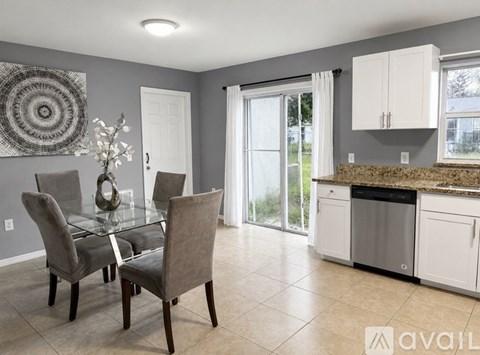 A kitchen with a table and chairs in front of a window.