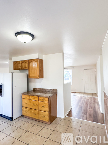 A kitchen with a white refrigerator and wooden cabinets.