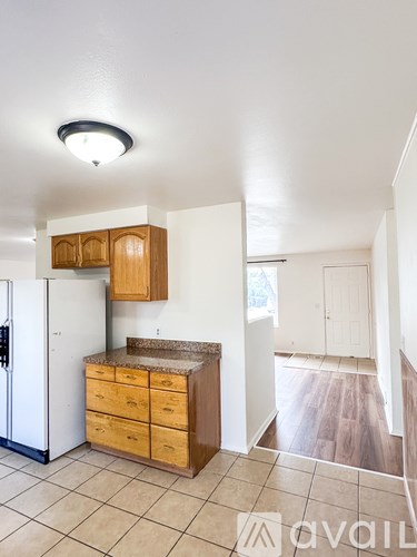 A kitchen with a white refrigerator and wooden cabinets.