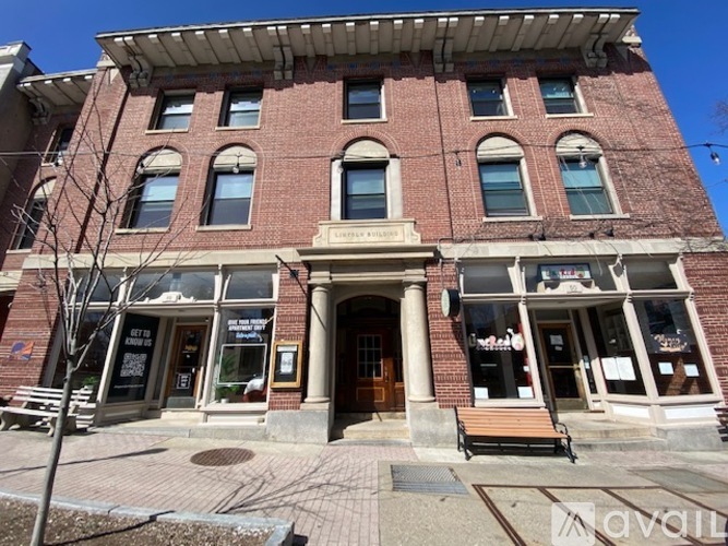 A red brick building with a wooden door and windows.