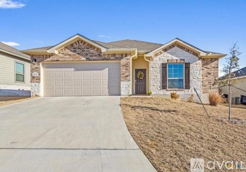 A house with a garage door and a driveway in front.
