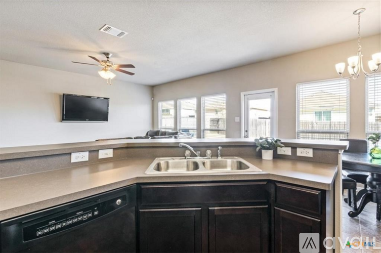 A kitchen with a black dishwasher and a black countertop.