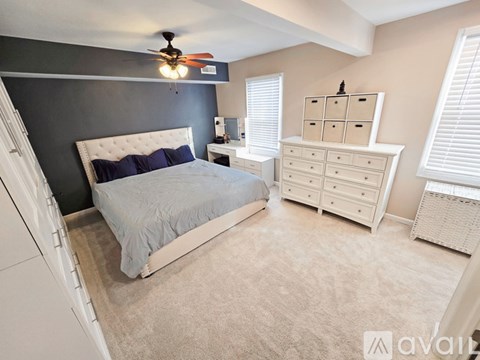 A bedroom with a bed, dresser, and window.