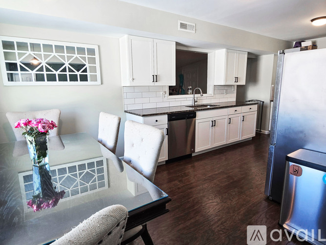 A kitchen with a glass table and a vase of flowers on it.