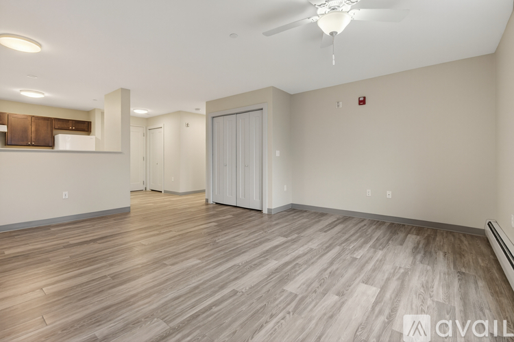 A spacious room with wood flooring and a ceiling fan.