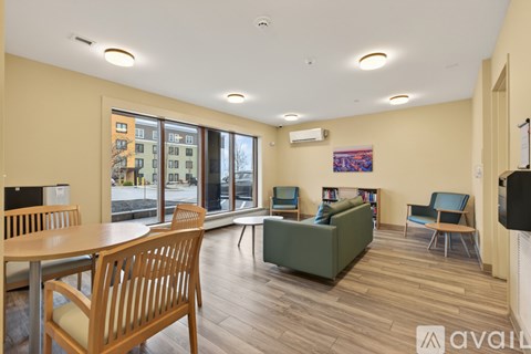A living room with a couch, chairs, and a television.