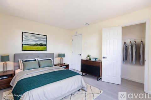 A bedroom with a large bed and a painting on the wall.