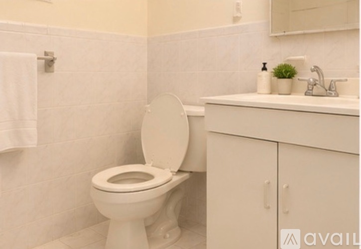 A white toilet with a white cabinet and a white sink.