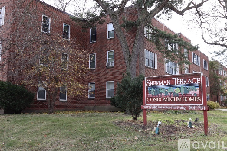 A sign for Sherman Terrace Condominium Homes stands in front of a brick building.