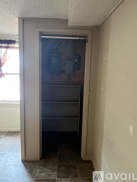 A room with a door leading to a dark room.