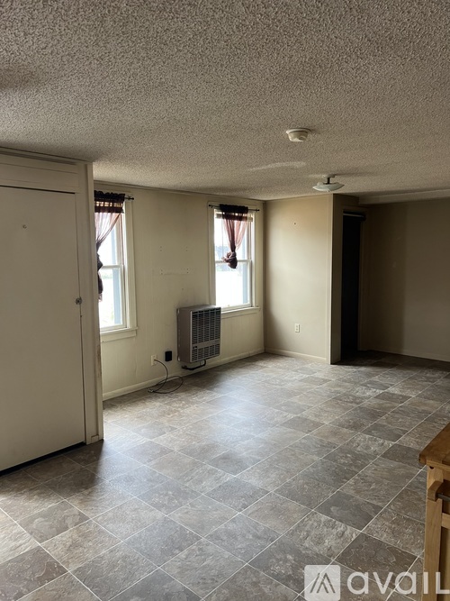 A room with a tile floor and a window with a closed curtain.