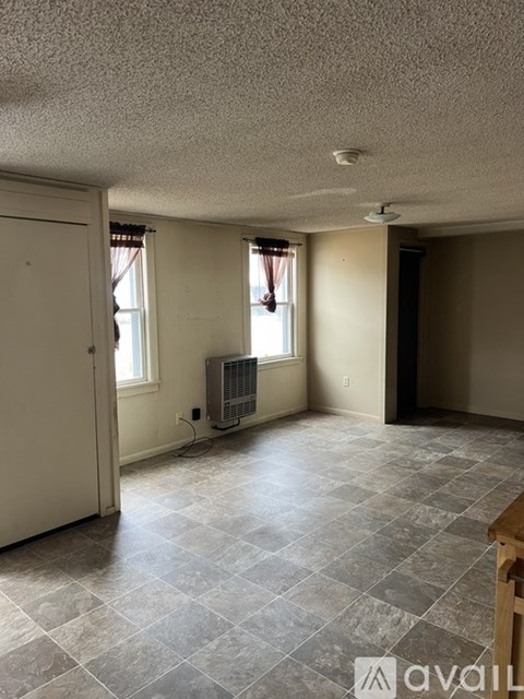 A room with a tile floor and a window with a closed curtain.