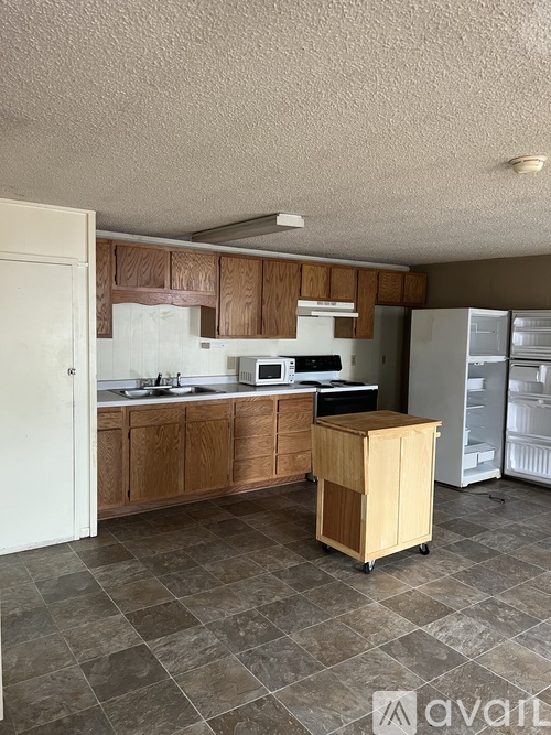 A kitchen with wooden cabinets and a white fridge.