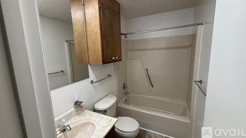 A bathroom with a toilet, sink, and bathtub.