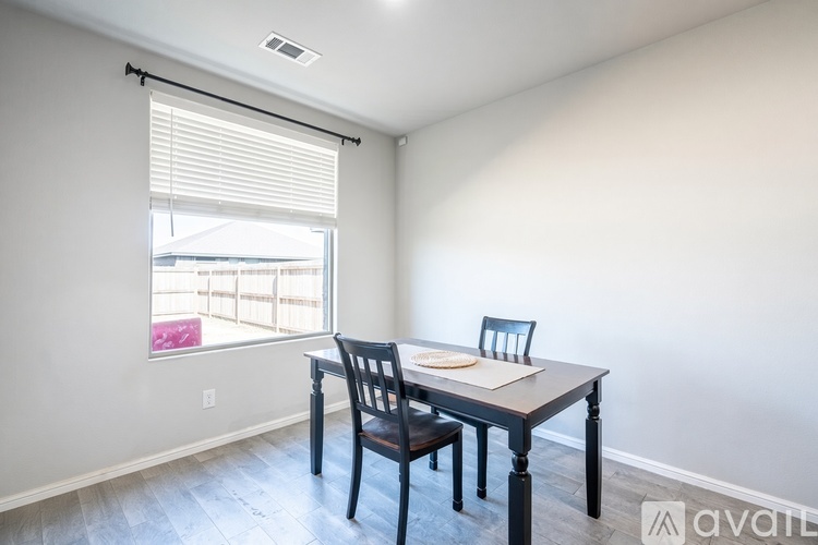 A dining room with a table and chairs.