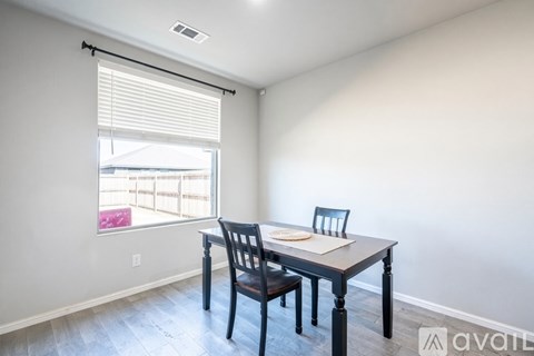 A dining room with a table and chairs.