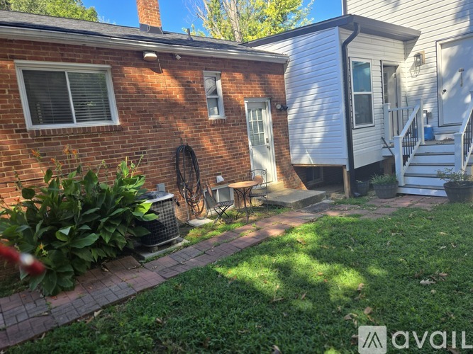 A house with a brick exterior and a white exterior house with a porch.