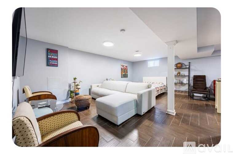 A living room with a white sofa and wooden flooring.