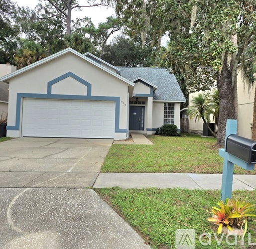 A house with a blue garage door and a mailbox in front.