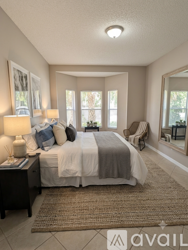 A bedroom with a bed, nightstand, and a rug.