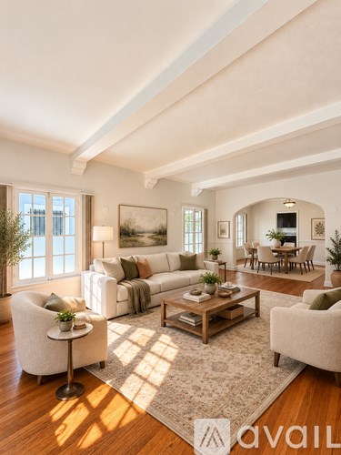 A living room with a large couch, a chair, a coffee table, and a painting on the wall.