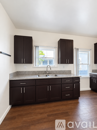 A kitchen with dark brown cabinets and a granite countertop.