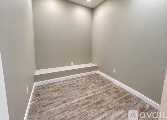 A room with wooden flooring and beige walls.