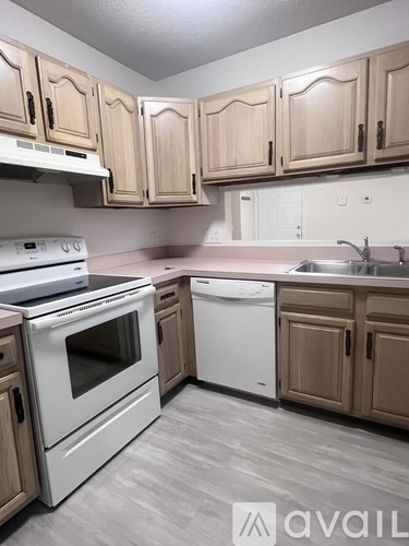 A kitchen with wooden cabinets and white appliances.