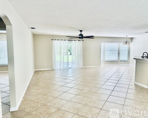 A spacious living room with a fan and tiled flooring.