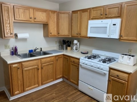 A kitchen with wooden cabinets and a white stove.