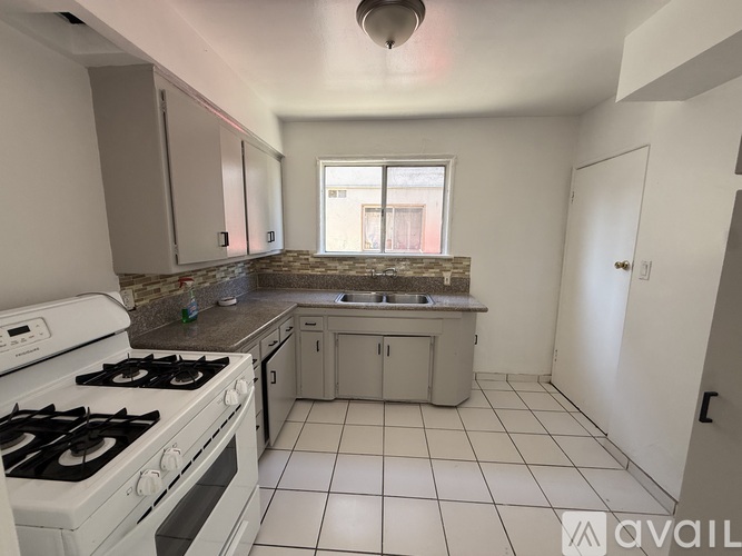 A kitchen with a white stove and a window.