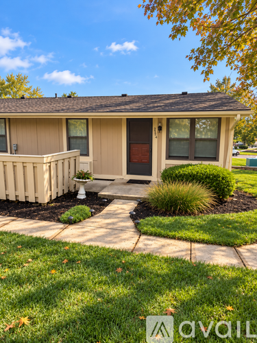 A small house with a brown door and a brown fence.