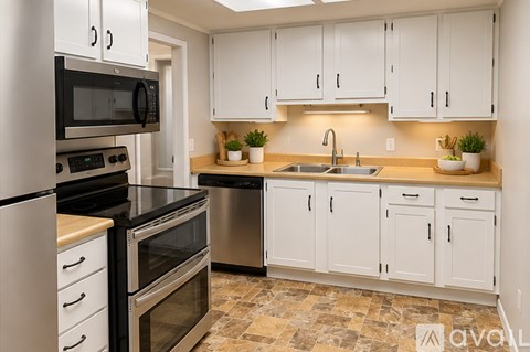 A kitchen with white cabinets and a black stove top oven.