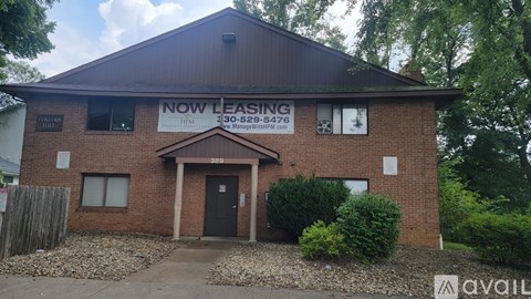 A building with a sign that says "NOW LEASING" and a phone number.