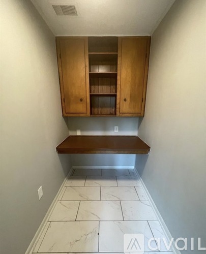 A kitchen with a bench under a cabinet.