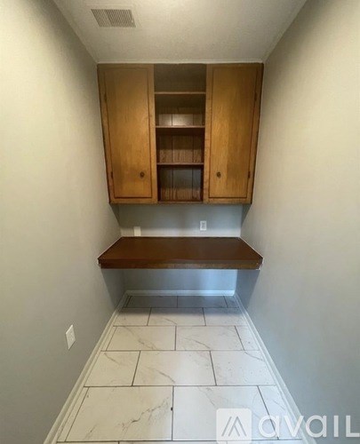 A kitchen with a bench under a cabinet.