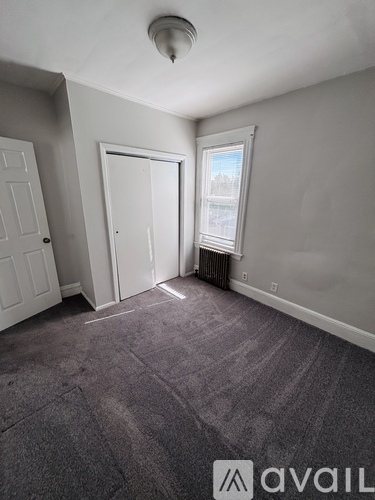 A room with grey carpet and white walls.
