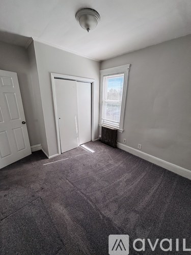 A room with grey carpet and white walls.