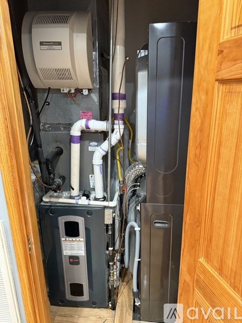 A view of a room showing a water heater and pipes.