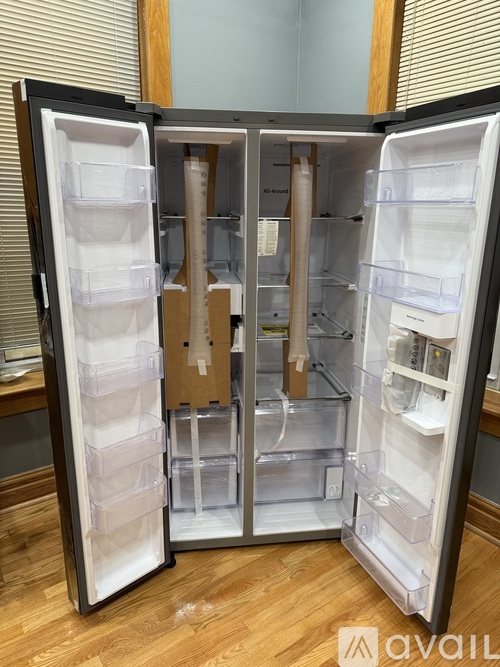A black refrigerator with its door open and all shelves empty.
